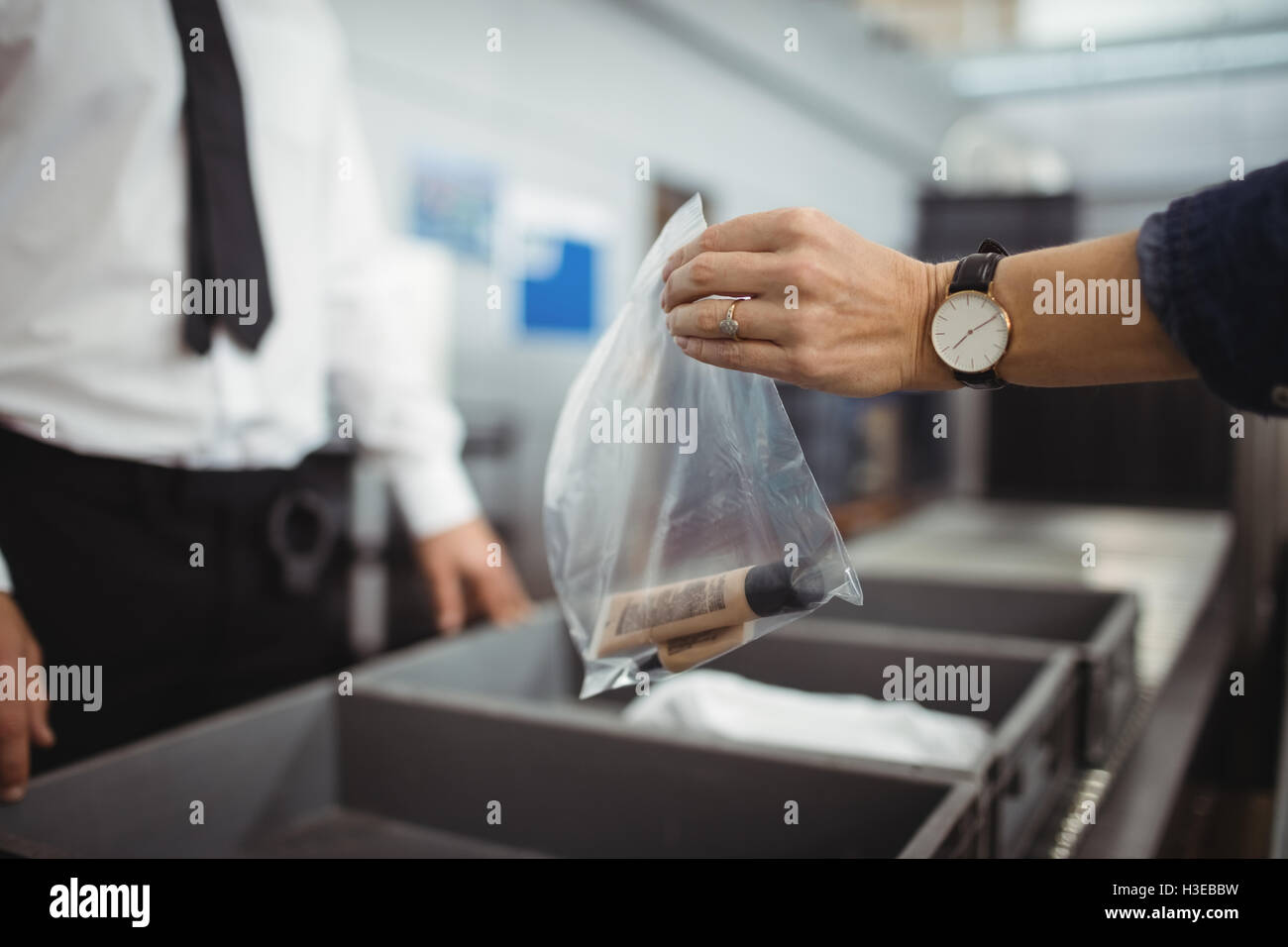 Passenger putting plastic bag into tray for security check Stock Photo