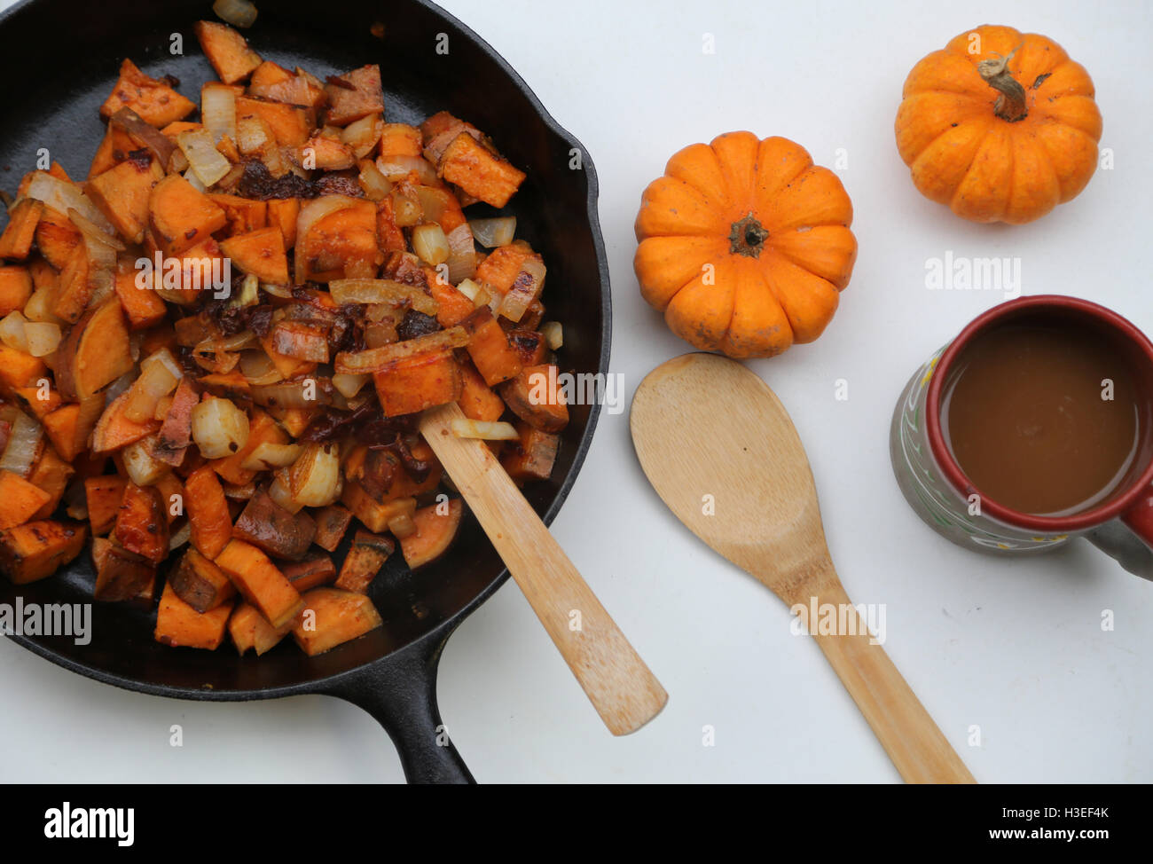 Orange Potatoes and pumpkins in pan with coffee cup. Fall Stock Photo