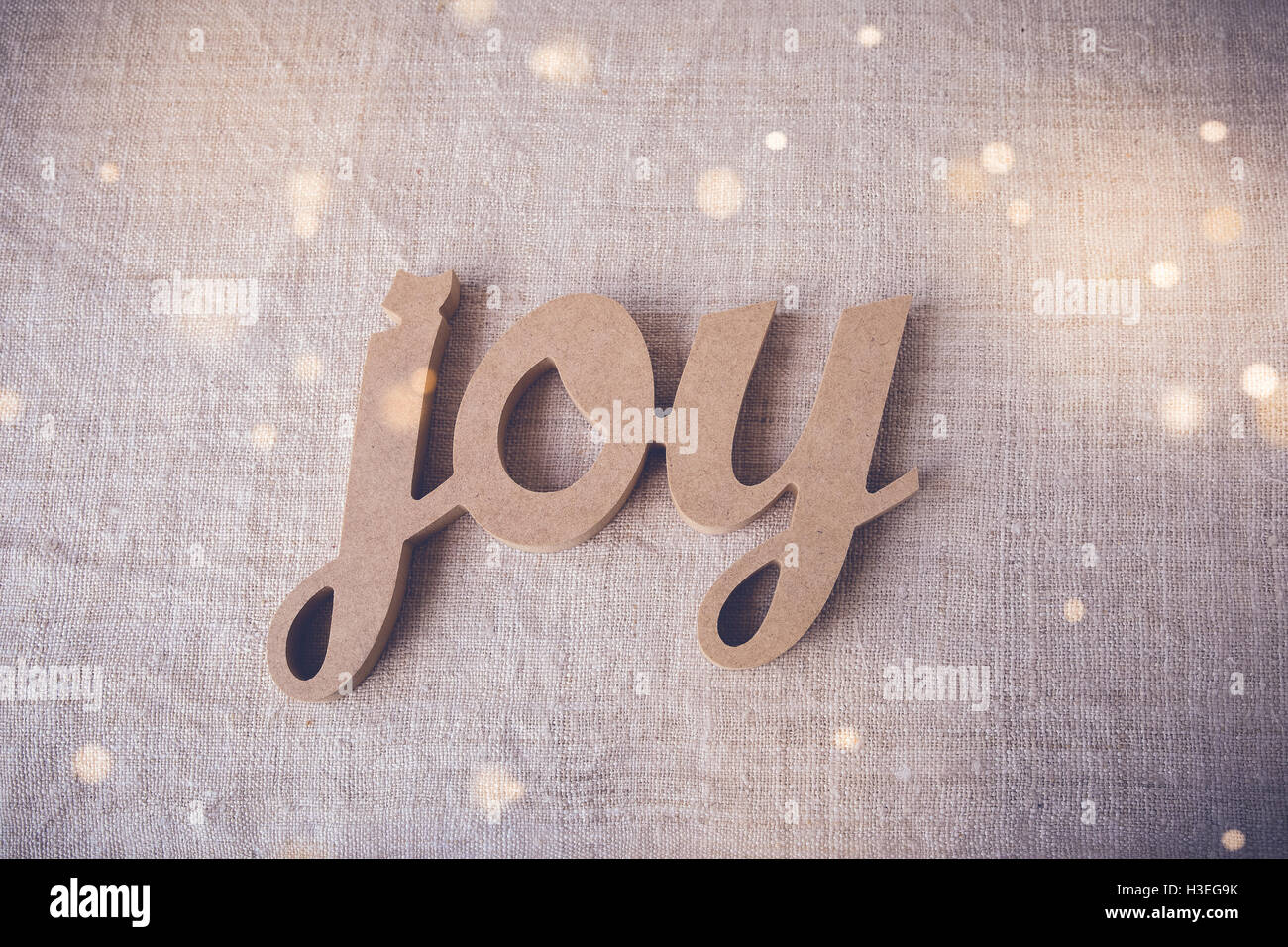 Joy word on fairy light toning background Stock Photo