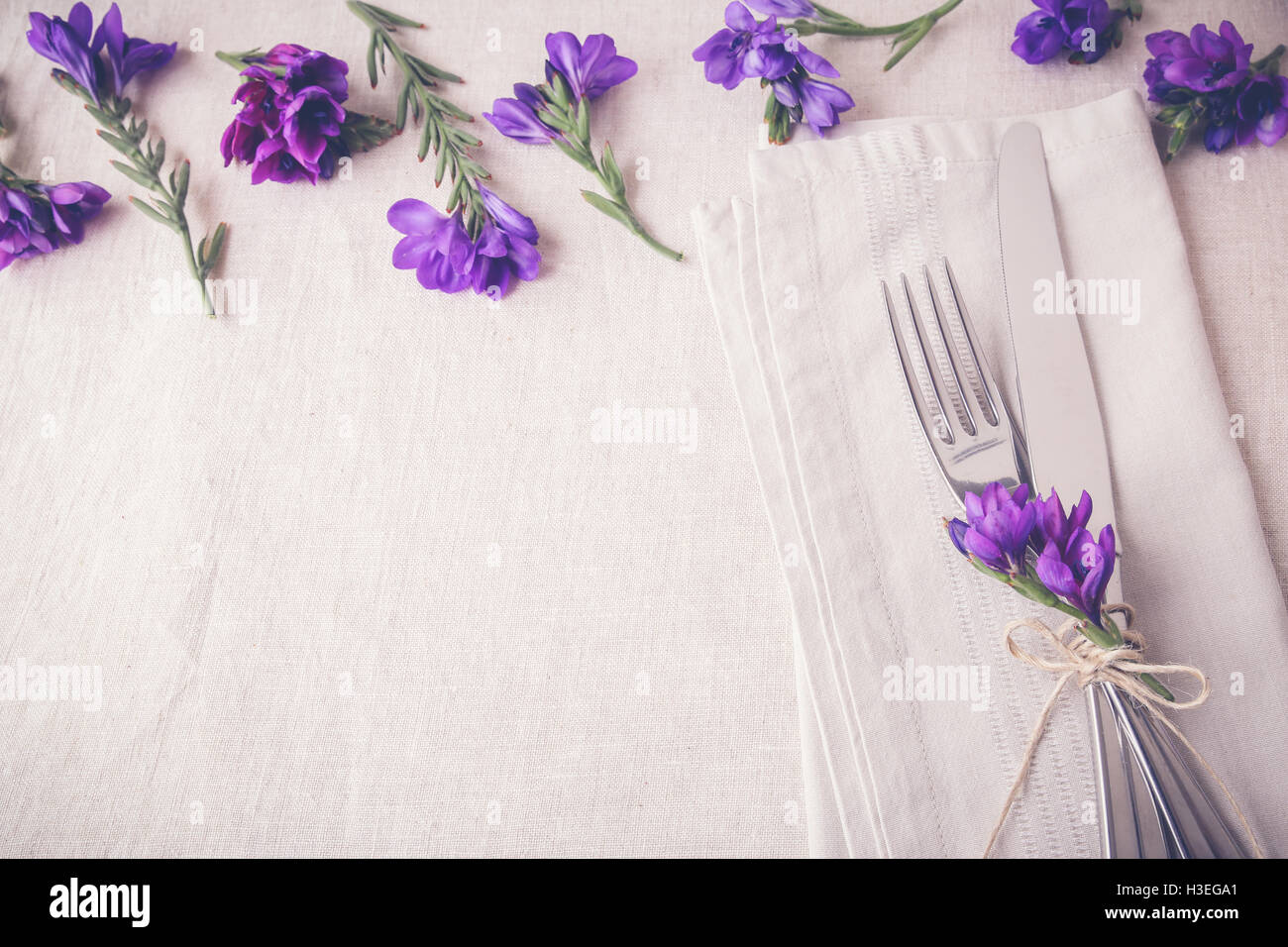 Purple flower table place setting on linen toning copy space background Stock Photo
