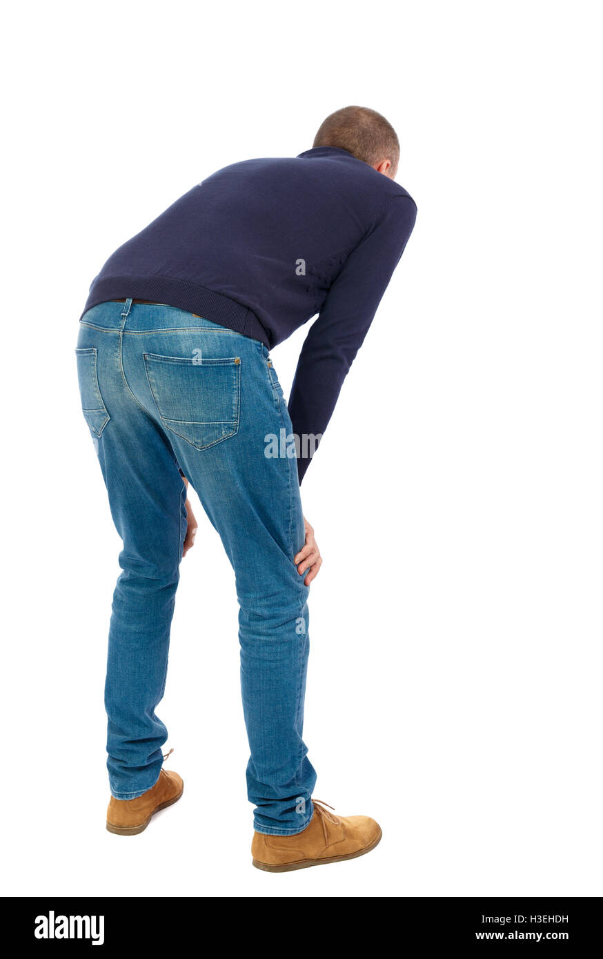 Back view of a man who rests in his hands leaning. Standing young guy. Rear view people collection. backside view of person. Isolated over white background. Man in warm jacket is resting wearily. Stock Photo