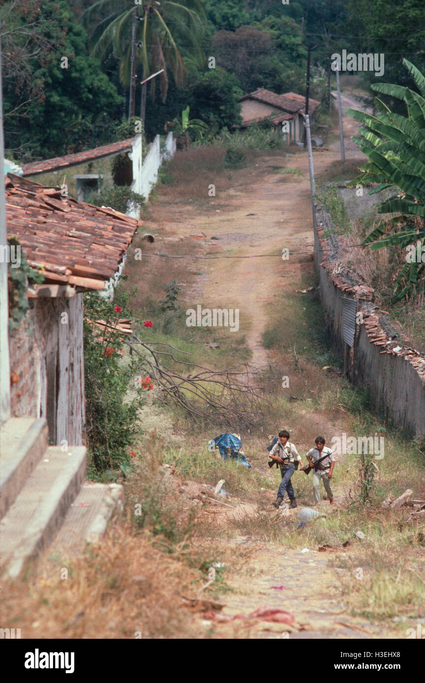 TENANCINGO,  EL SALVADOR, MARCH 1984: - Within the FPL Guerrilla's Zones of Control.  Two guerrilla fighters make their way through the abandoned streets of this contested town. Stock Photo