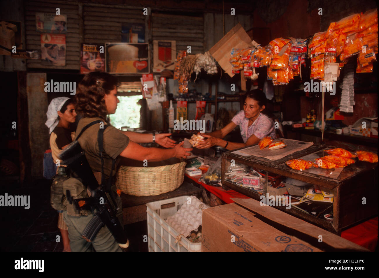 TENANCINGO,  EL SALVADOR, MARCH 1984: - Within the FPL Guerrilla's Zones of Control.  Guerrilla fighter inside a shop that still functions in the partly ruined town of Tenancingo. Stock Photo