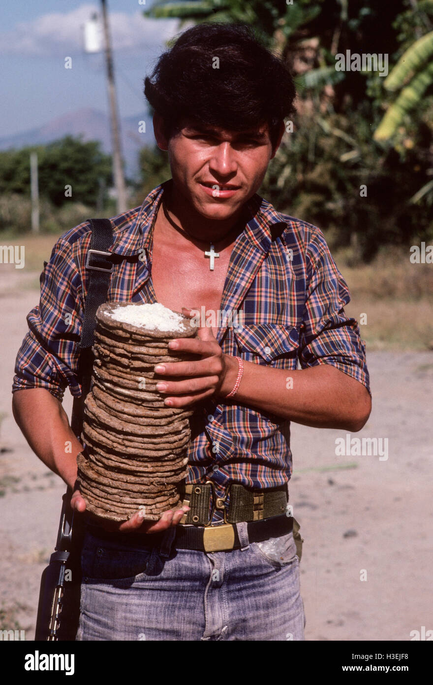 TENANCINGO,  EL SALVADOR, MARCH 1984: - Within the FPL Guerrilla's Zones of Control. An FPL fighter with a stack of tortillas and salt. Stock Photo