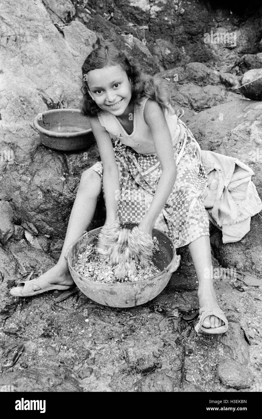 CHALATENANGO,  EL SALVADOR, FEB 1984: - Within the FPL Guerrilla's Zones of Control   A girl mixing maize soaked overnight to to be ground into flour for tortillas. Stock Photo