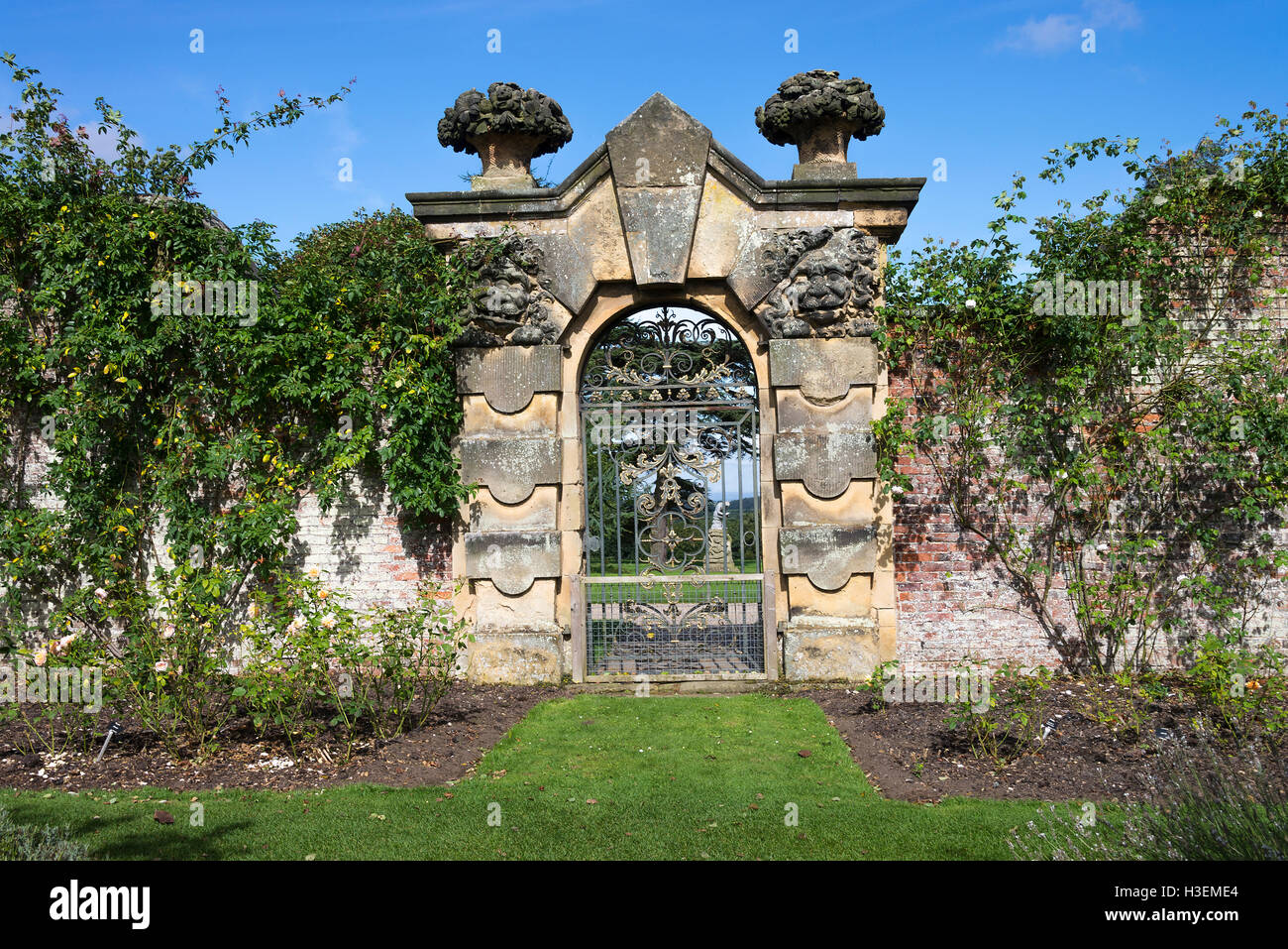 Intricate Stone Gateway with Wrought Iron Gate in the Walled Garden at Castle Howard near York North Yorkshire England United Kingdom UK Stock Photo