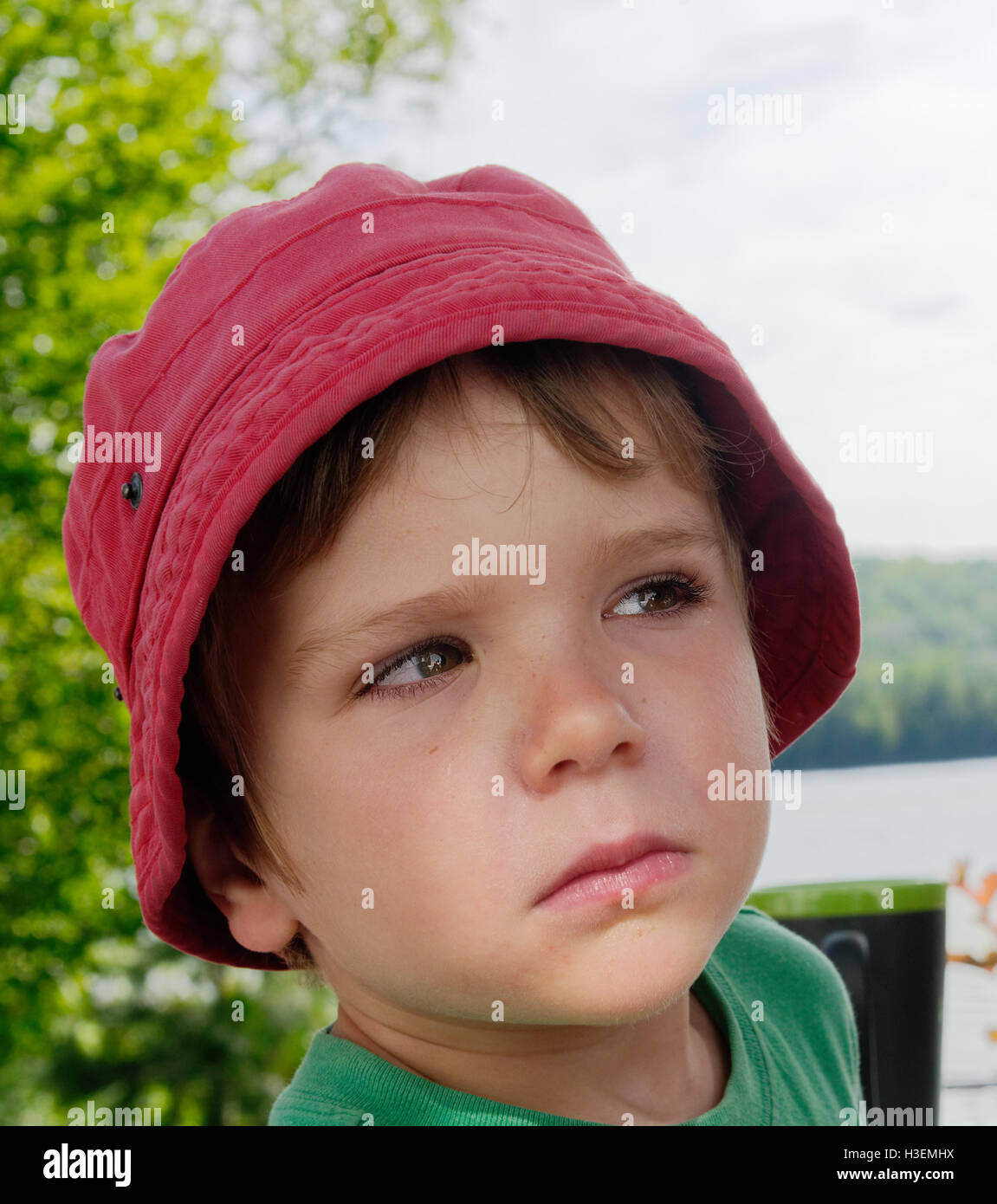 A little boy (4 yr old) giving his mum an evil look after she suncreamed his face against his wishes. Stock Photo