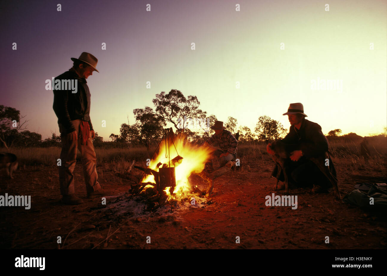 Three campers boiling a billy over campfire, near Mt Isa, Queensland, Australia Stock Photo