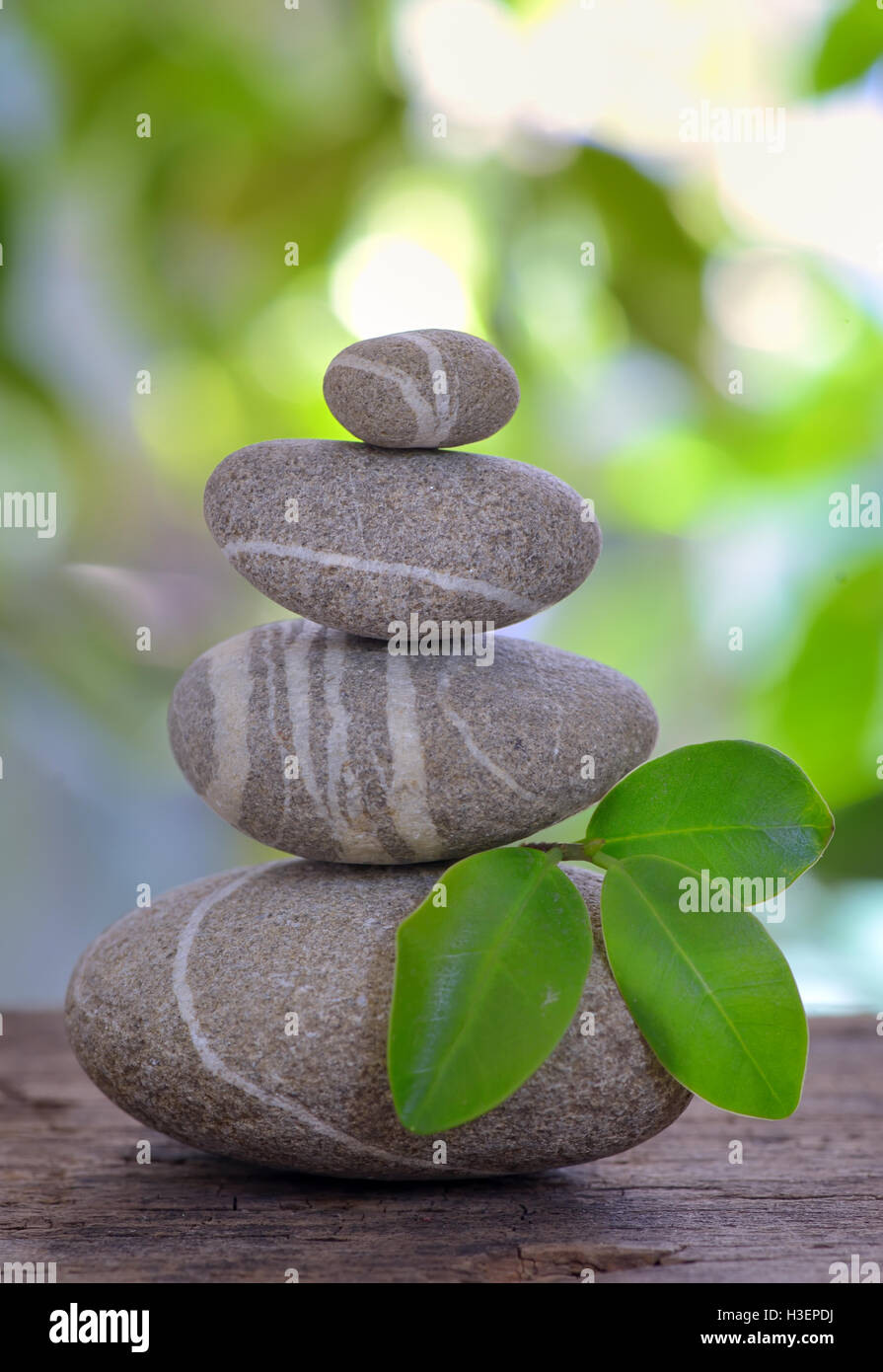 Balanced pebbles isolated on wooden table Stock Photo