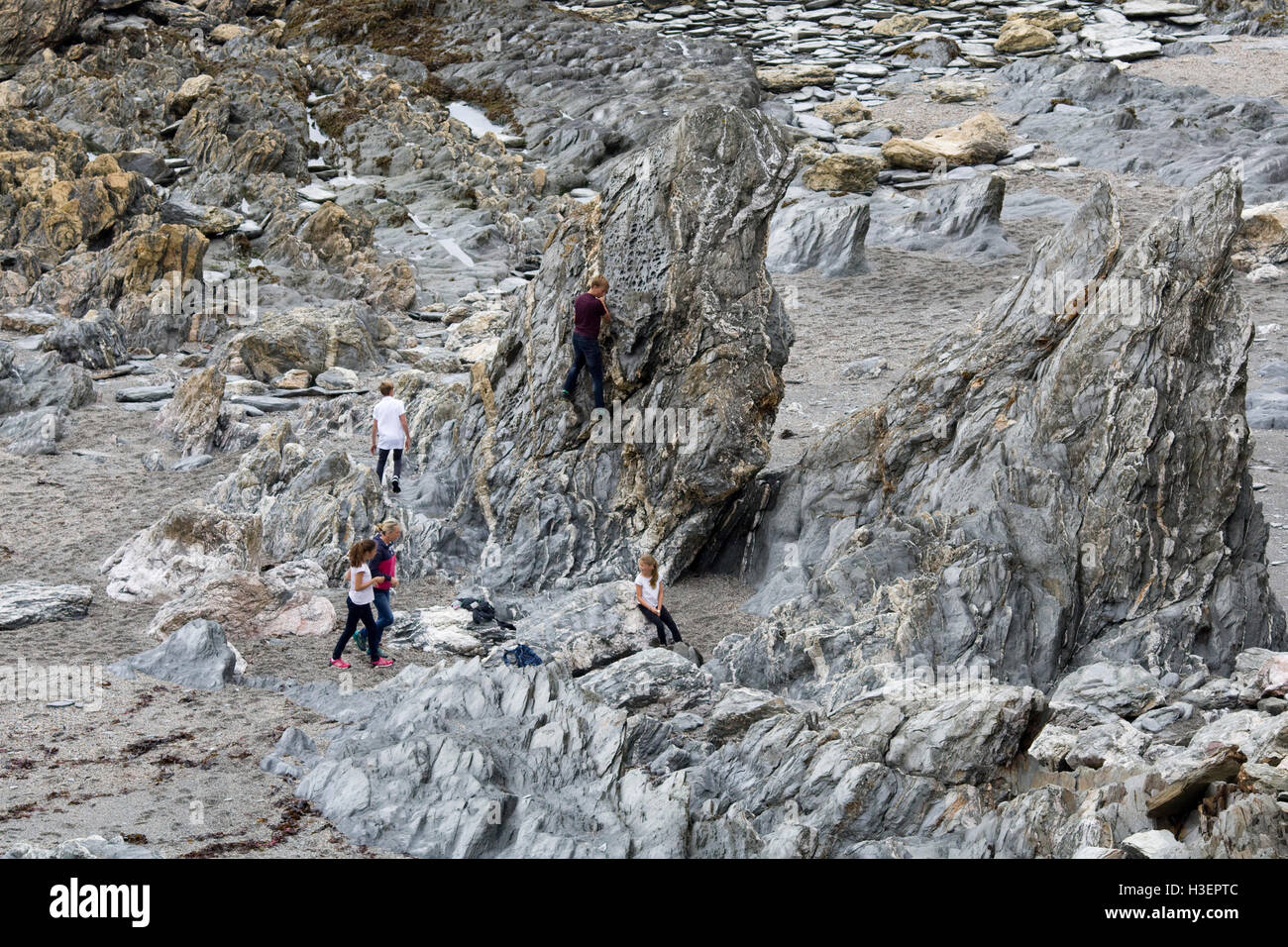 Children climbing rock face without protective equipment Stock Photo