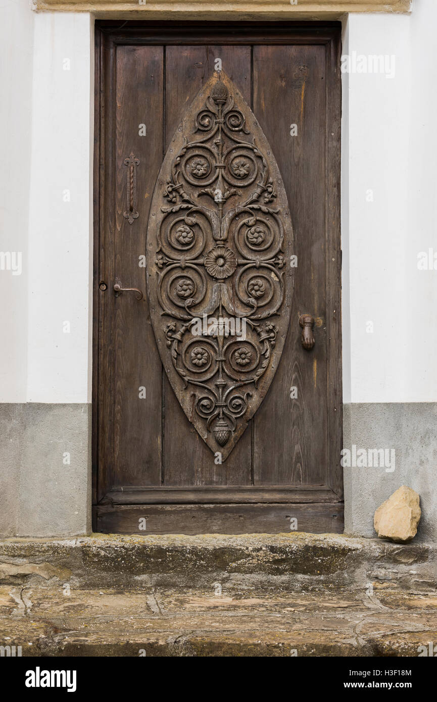 Old carved wooden and crooked door in Montechiaro d'Acqui, Piedmonte, Italy Stock Photo