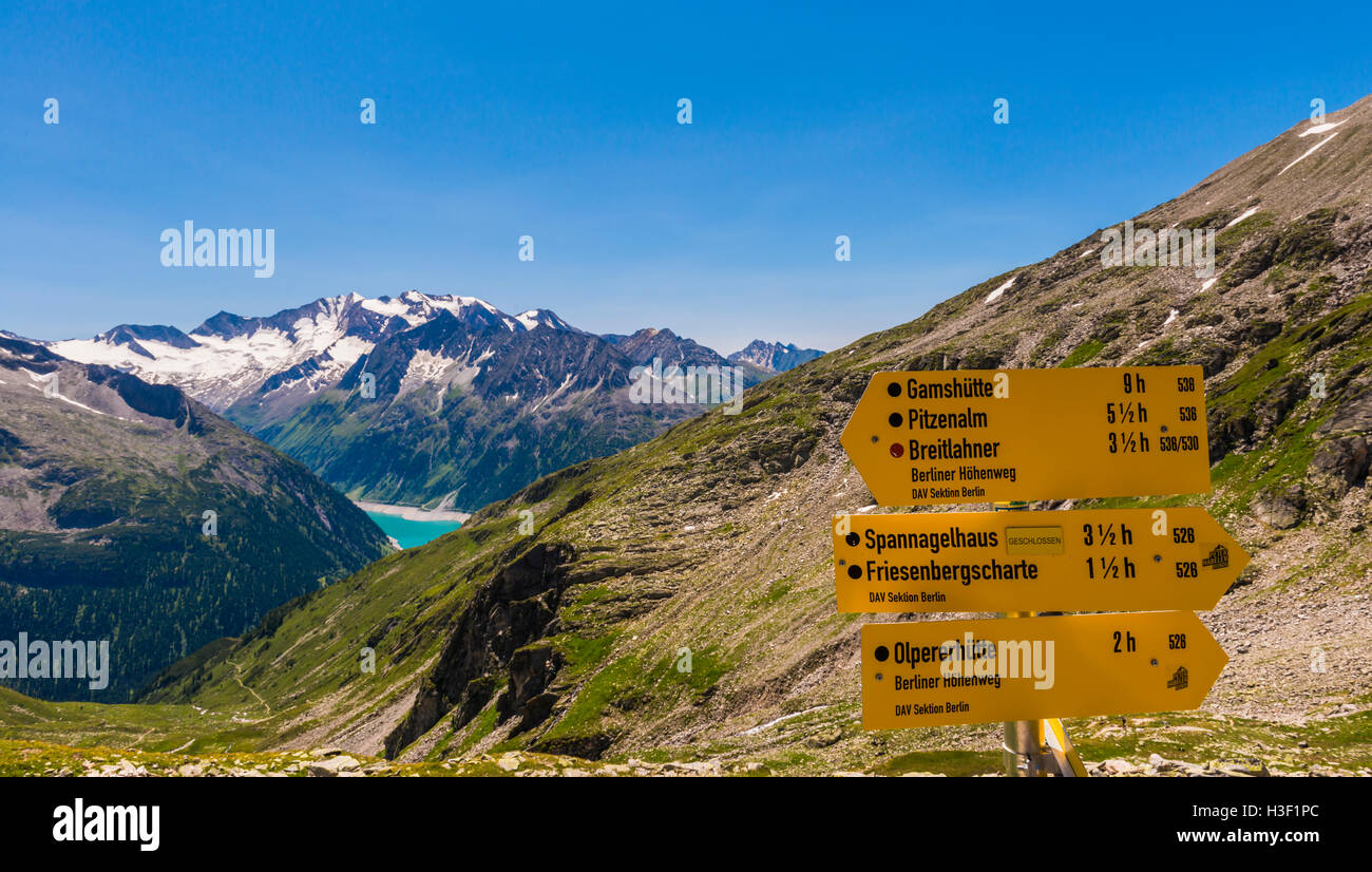 Yellow hiking signs in the Austrian mountains - Zillertal - in the summer time. Stock Photo