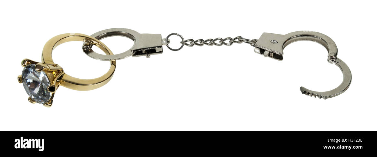 Handcuffs and a gold diamond engagement ring sparkles brightly in the
