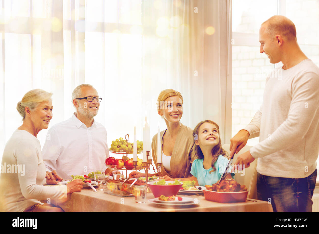smiling family having holiday dinner at home Stock Photo - Alamy