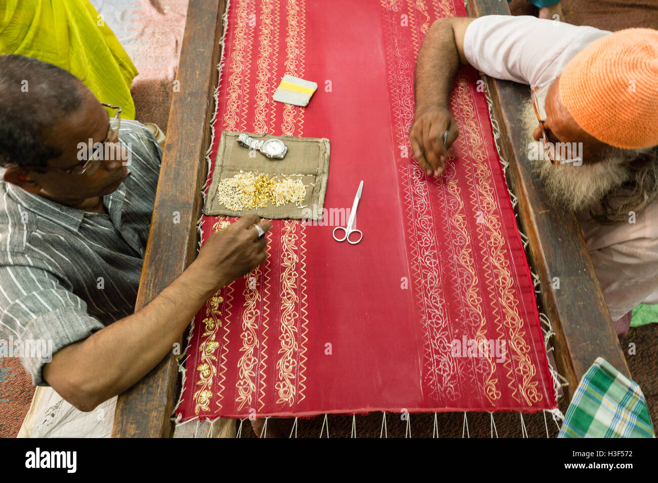 Craftsmen performing embroidery work on a Saree in Hyderabad,India Stock Photo