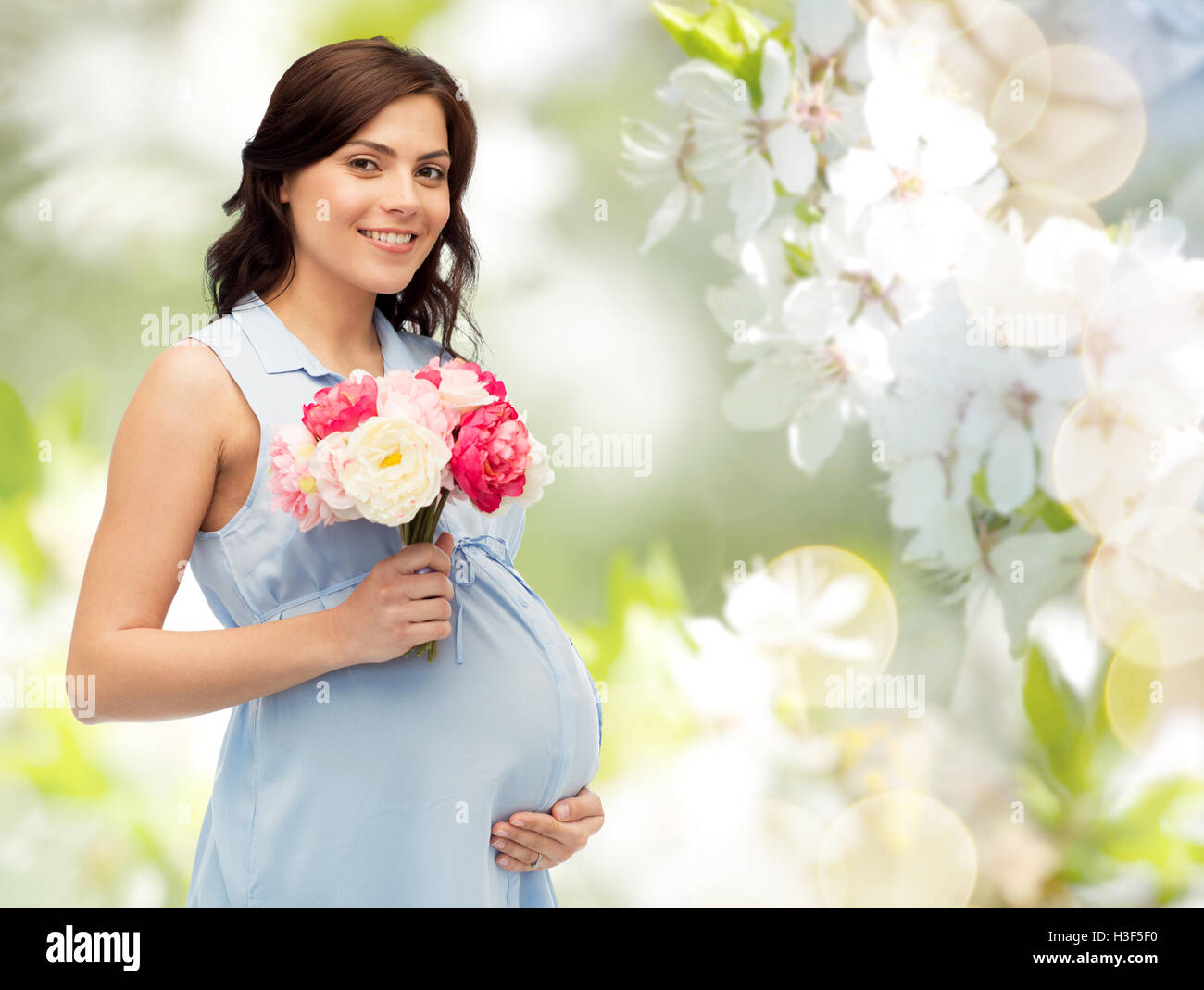 happy pregnant woman with flowers touching belly Stock Photo Alamy