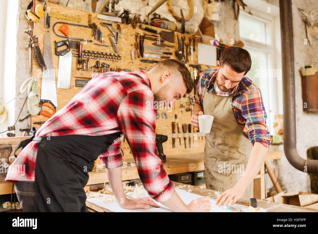 Carpenter Using Ruler carpenters with ruler and blueprint at workshop Stock Photo - Alamy