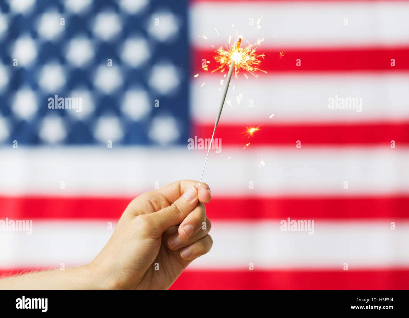 close up of hand with sparkler over american flag Stock Photo - Alamy