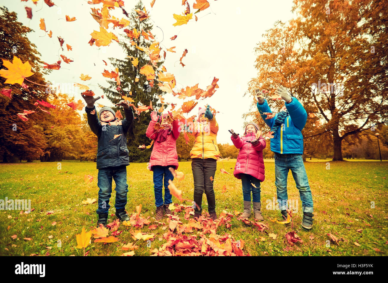 happy children playing with autumn leaves in park Stock Photo - Alamy