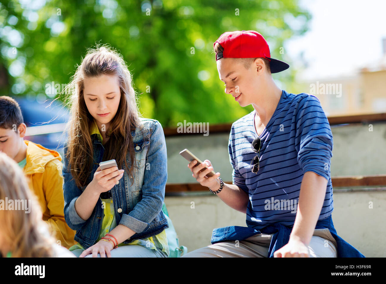 happy teenage friends with smartphones outdoors Stock Photo