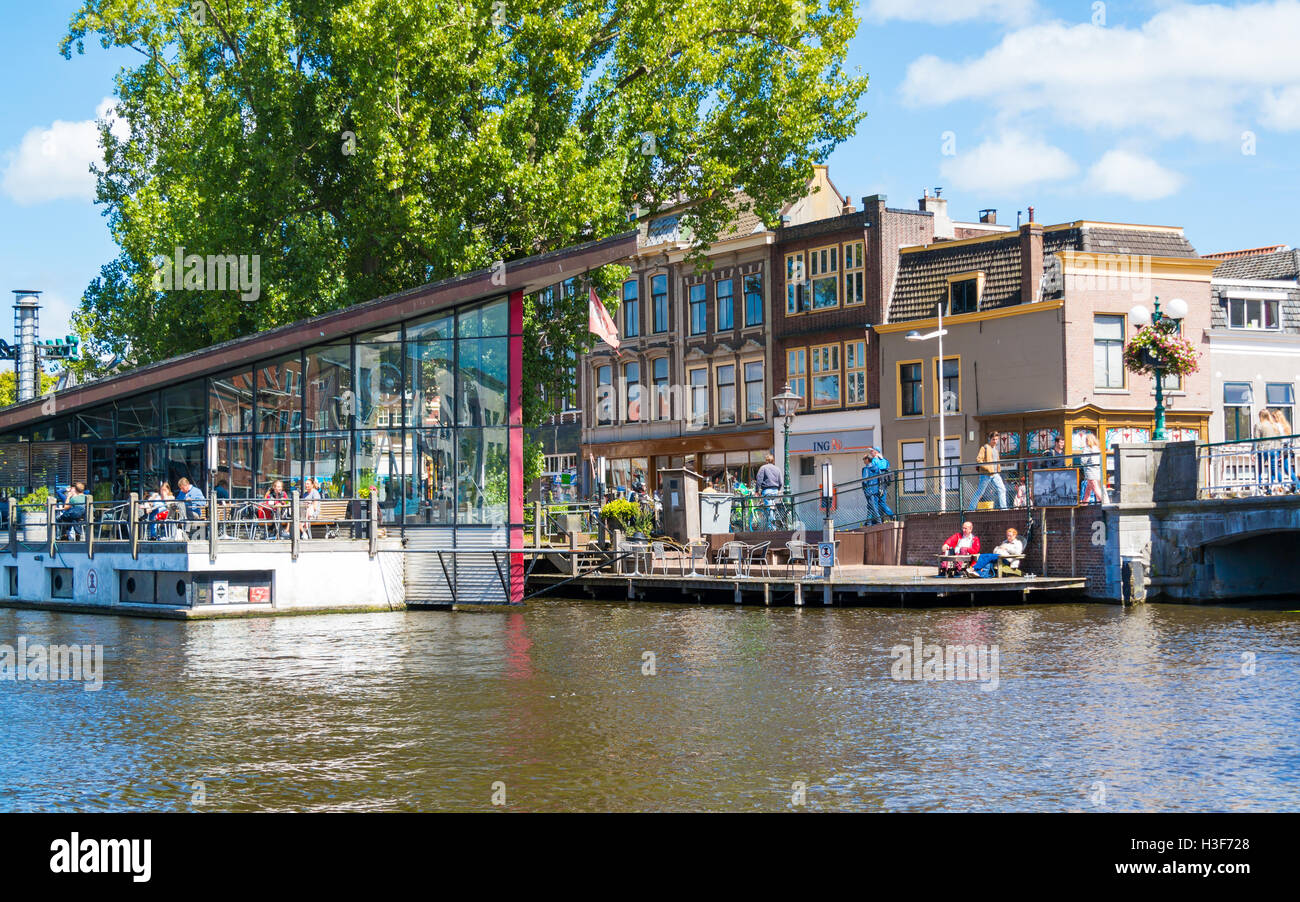 People on outdoor terrace of cafe on Galgewater canal in Leiden, South Holland, Netherlands Stock Photo