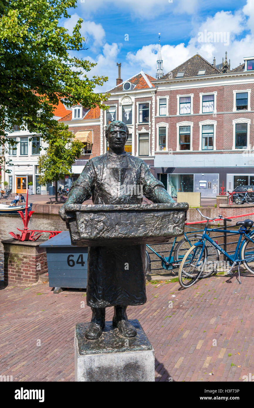 Statue of fishmonger on quay of New Rhine canal in old town of Leiden, South Holland, Netherlands Stock Photo