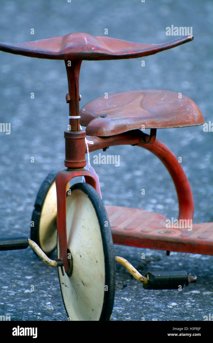 Close-Up of Antique Red Child's Tricycle with White Wheels at Hell's Kitchen Flea Market Manhattan NYC New York on Asphalt Stock Photo