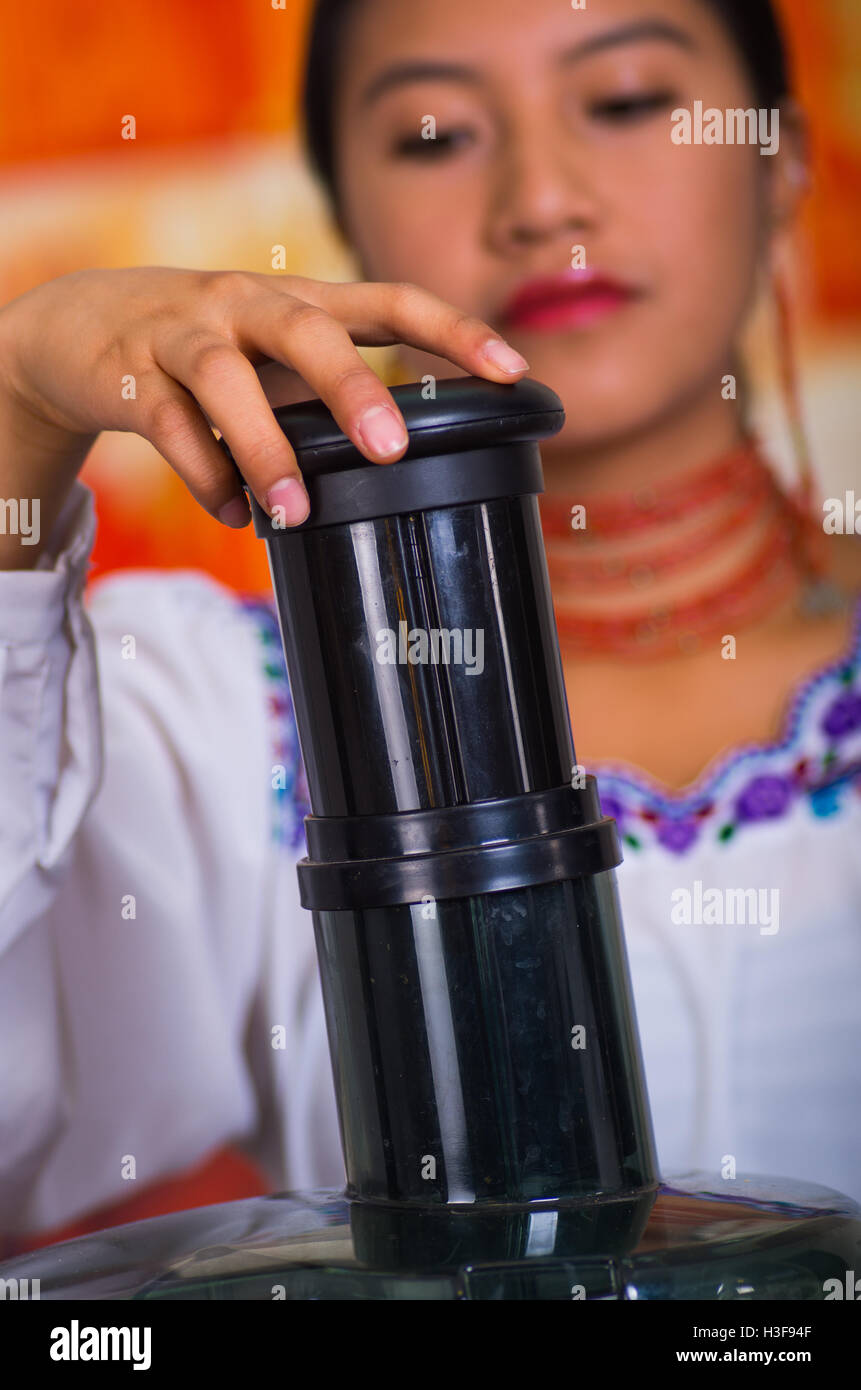 Closeup woman's hands using juice maker, pressing down plastic part