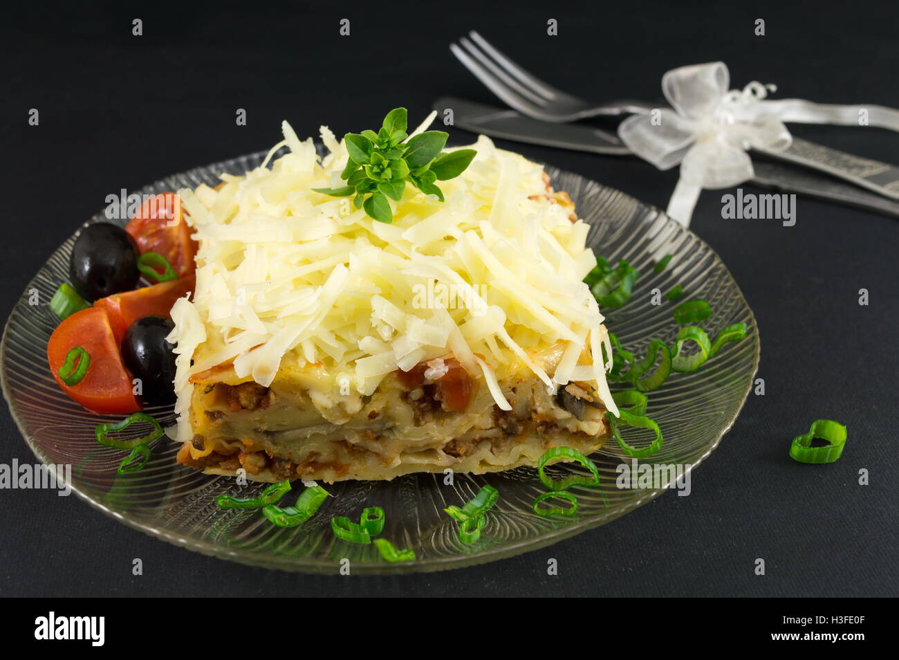 Lasagna portion served with fresh vegetables on a plate Stock Photo