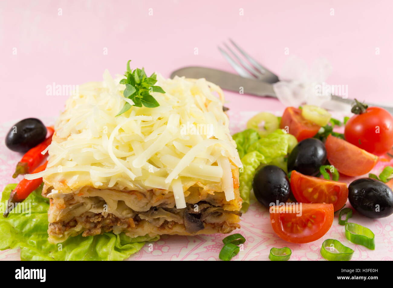 Lasagna portion served with fresh vegetables on a plate Stock Photo