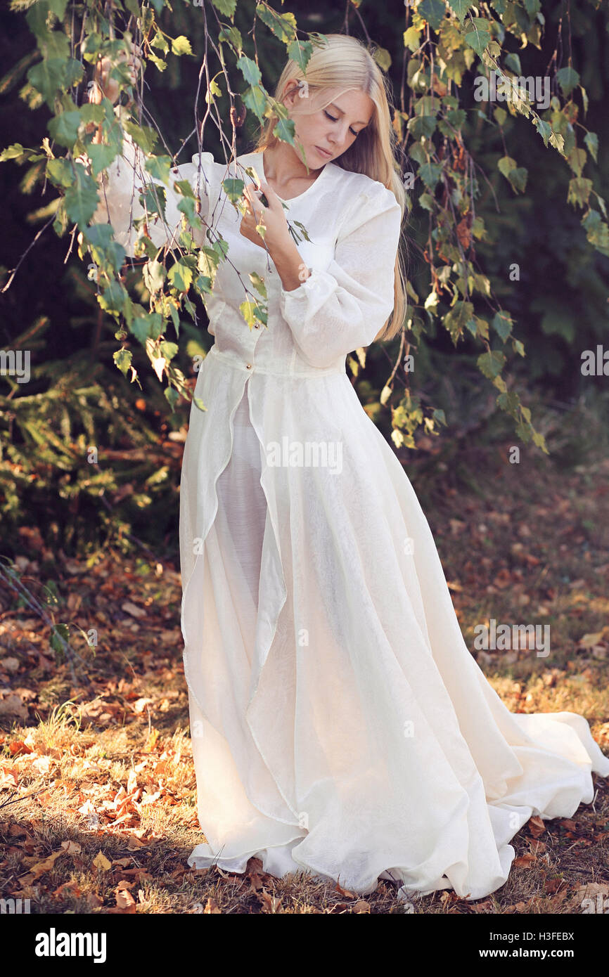 Romantic young woman among autumn leaves. Vintage colors Stock Photo