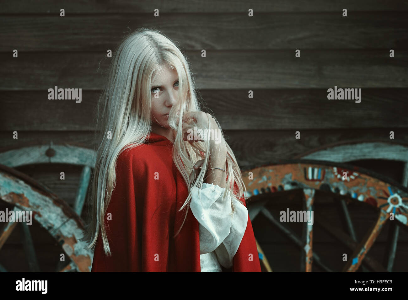 Beautiful blond woman with red cloak . Dark outdoor portrait Stock Photo