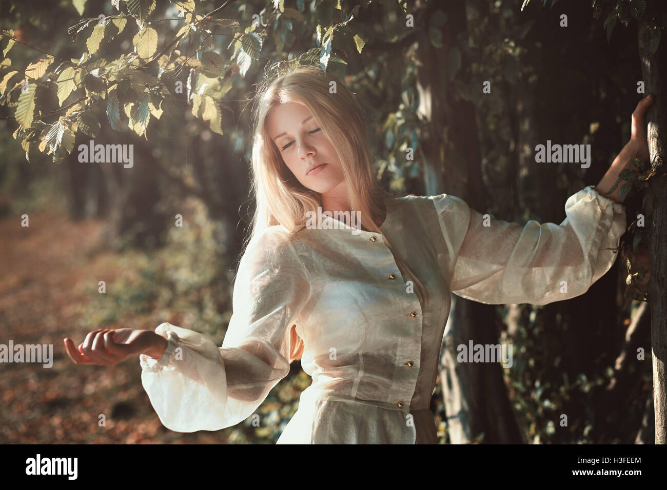 Beautiful young woman enjoying soft sunset light Stock Photo