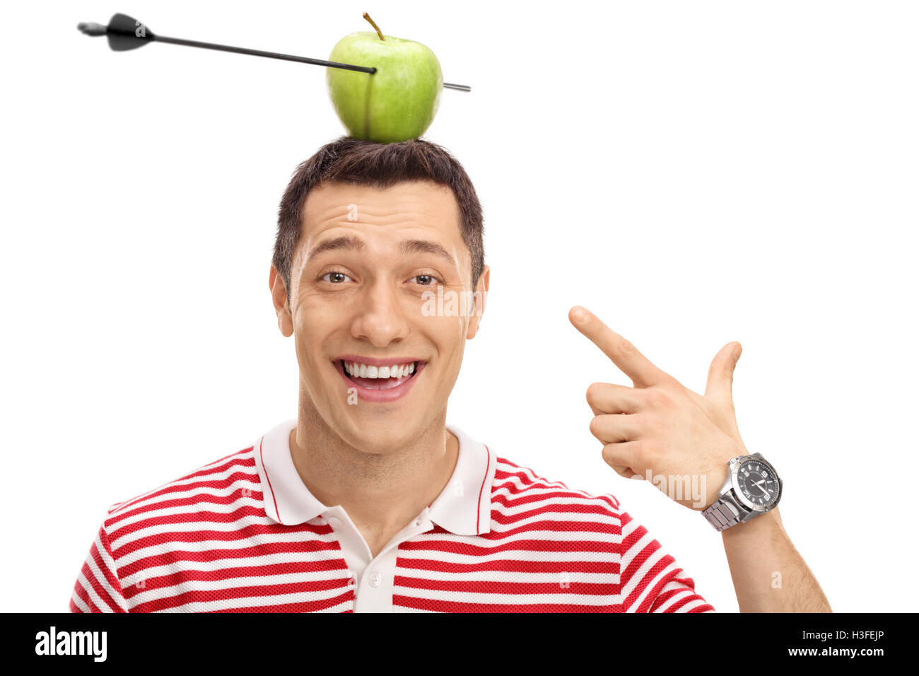 Delighted man pointing at an apple pierced by an arrow on his head isolated on white background Stock Photo