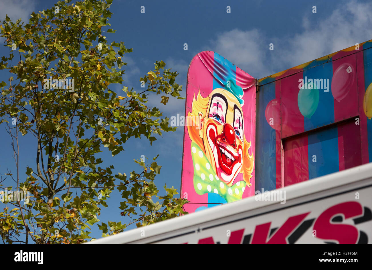Painted board of a clown's face at Goose Fair in Nottingham Stock Photo