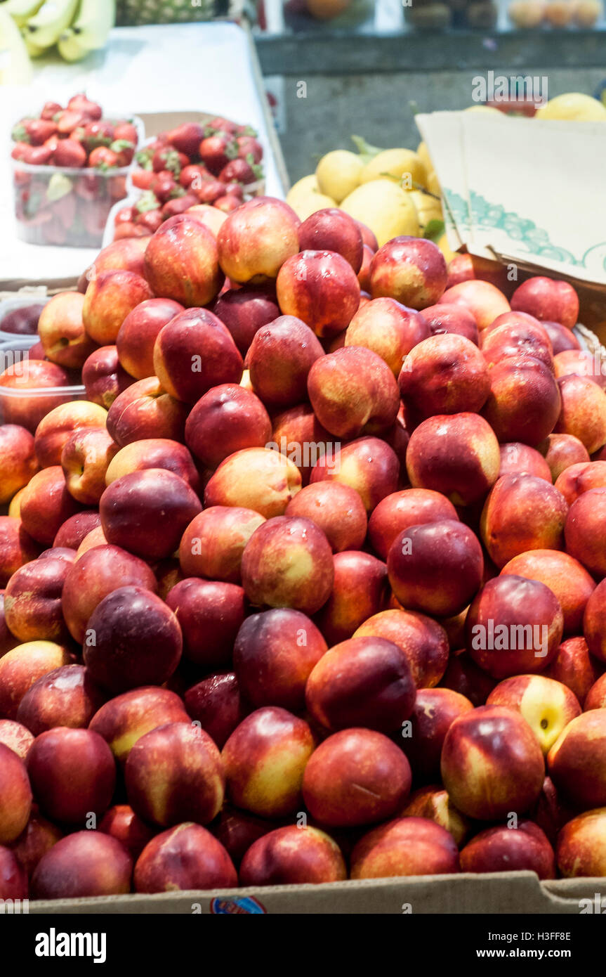 Close up of ripe fresh peaches on display for sale in farmers market. Stock Photo