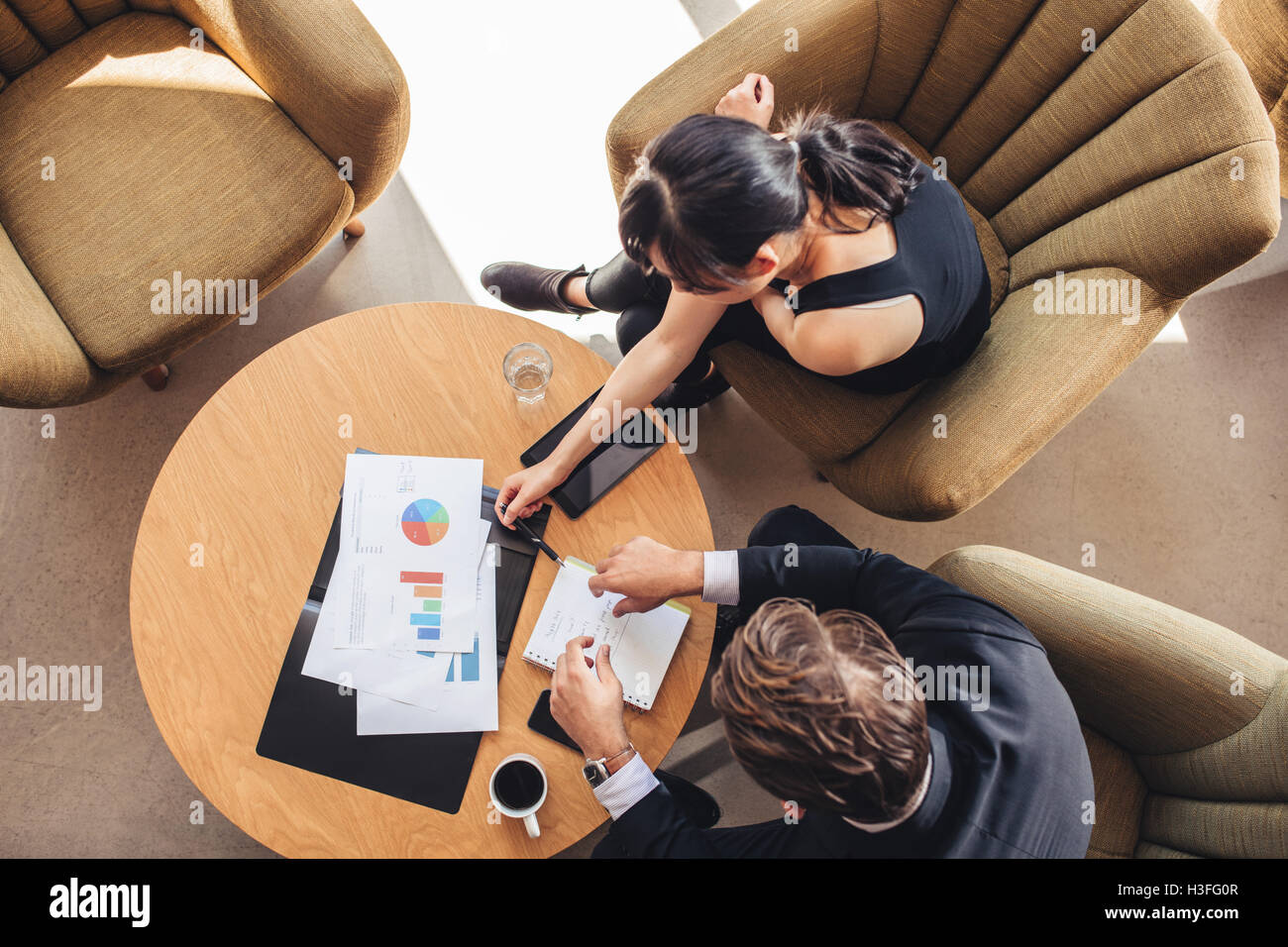 Top view of business colleague sitting at table during corporate meeting. Businessman and businesswoman discussing new project w Stock Photo