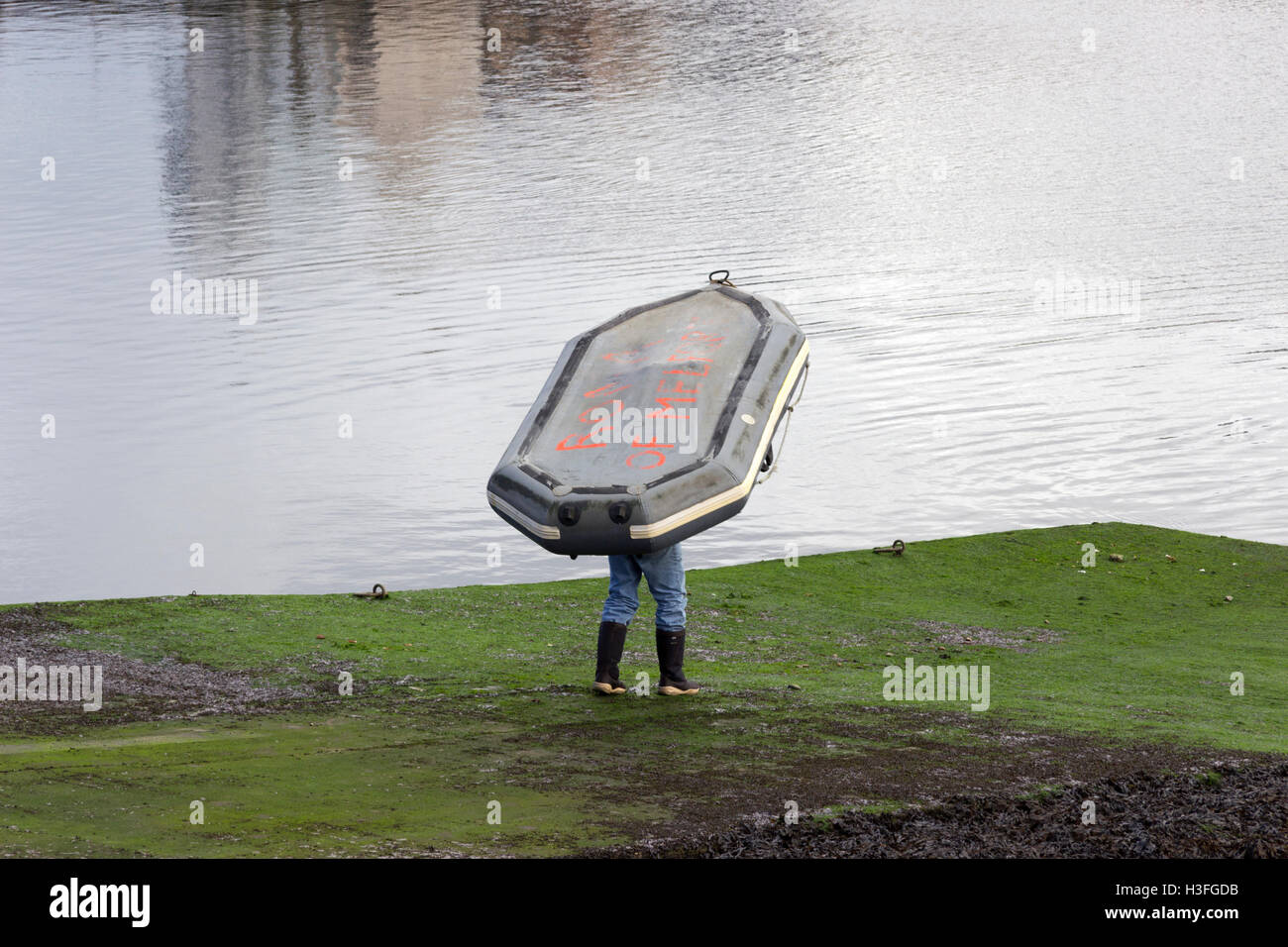 Man launching inflatable dingy at Stornoway Harbour Isle of Lewis