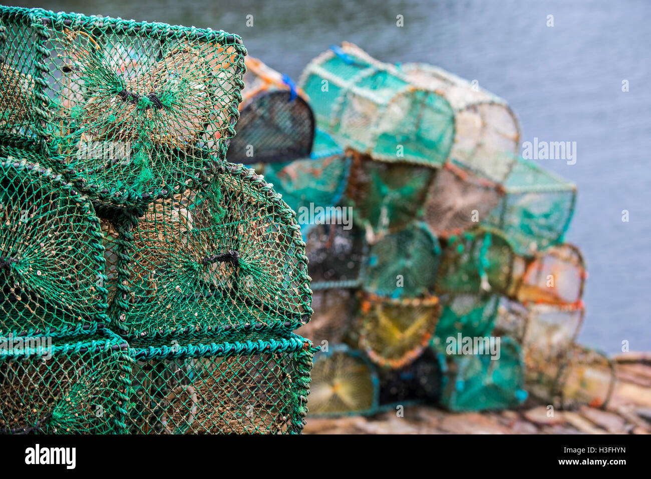 Stacked lobster creels / traps on quay in the Plockton Harbour, Scottish Highlands, Scotland, UK Stock Photo