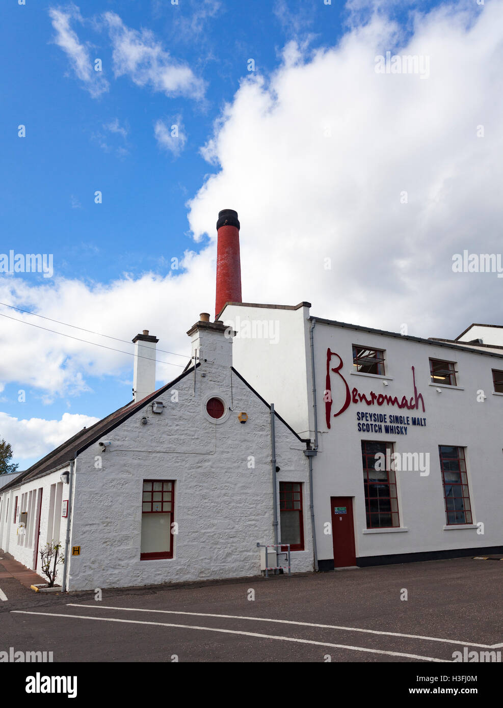 White distillery buildings at the  Benromach Distillery, Speyside, Highlands, Scotland with the brand name visible on the exterior of the building Stock Photo