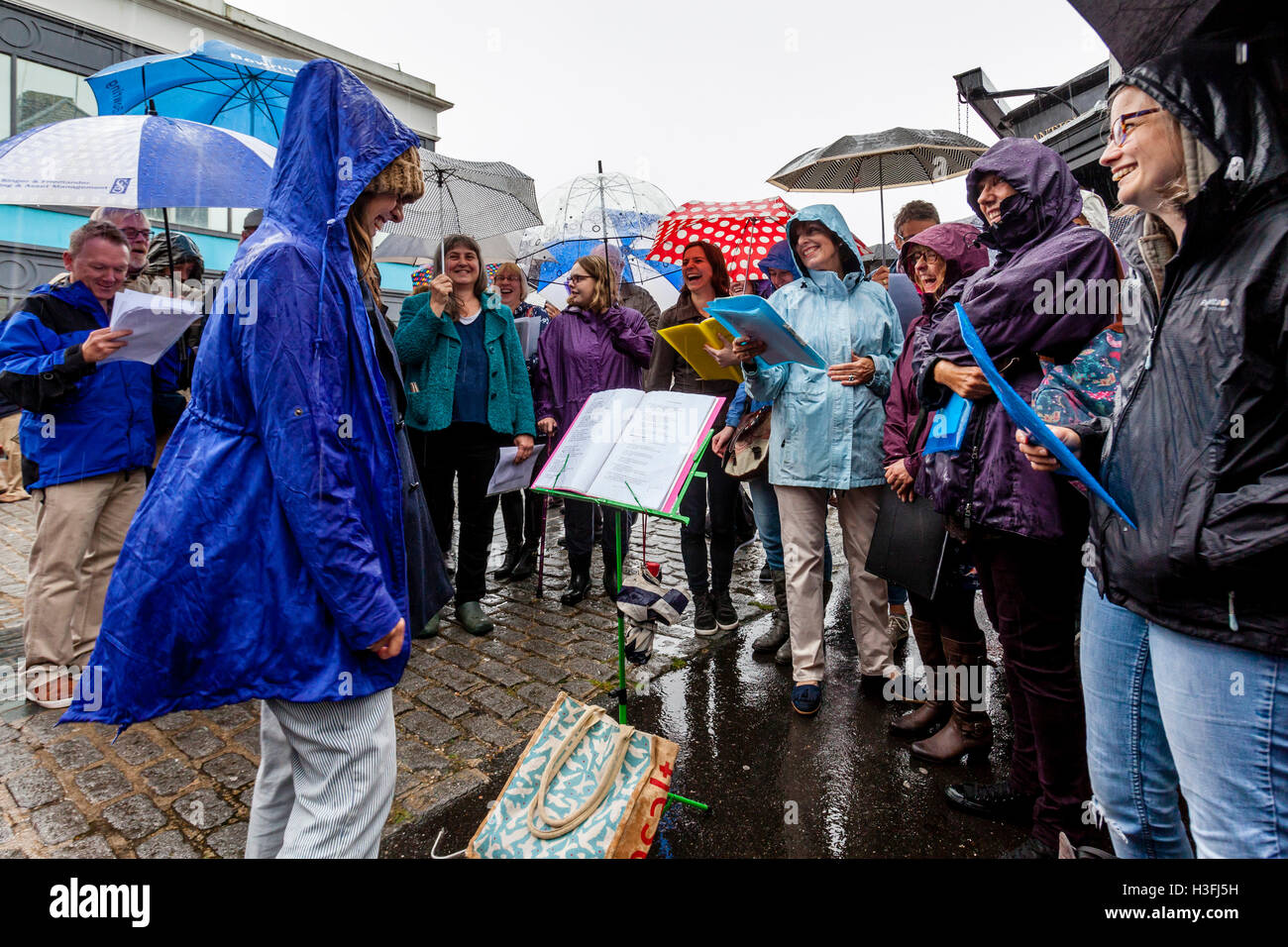 A Community Choir Performing In The Rain, The High Street, Lewes, Sussex, UK Stock Photo