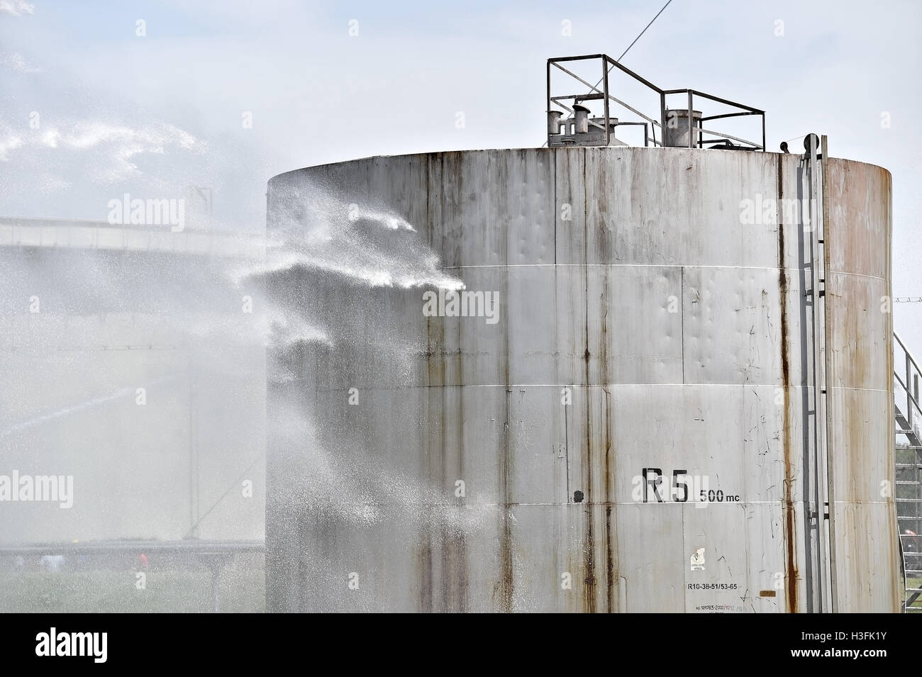 Firefighter water jet extinguish the fire started near a petrol storage tank Stock Photo Alamy