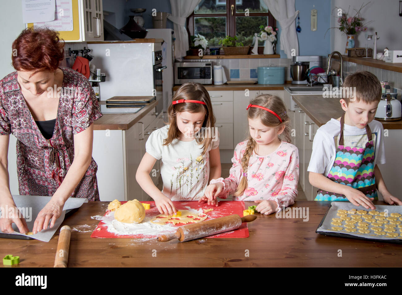 Kids helping their mum baking in the kitchen Stock Photo Alamy