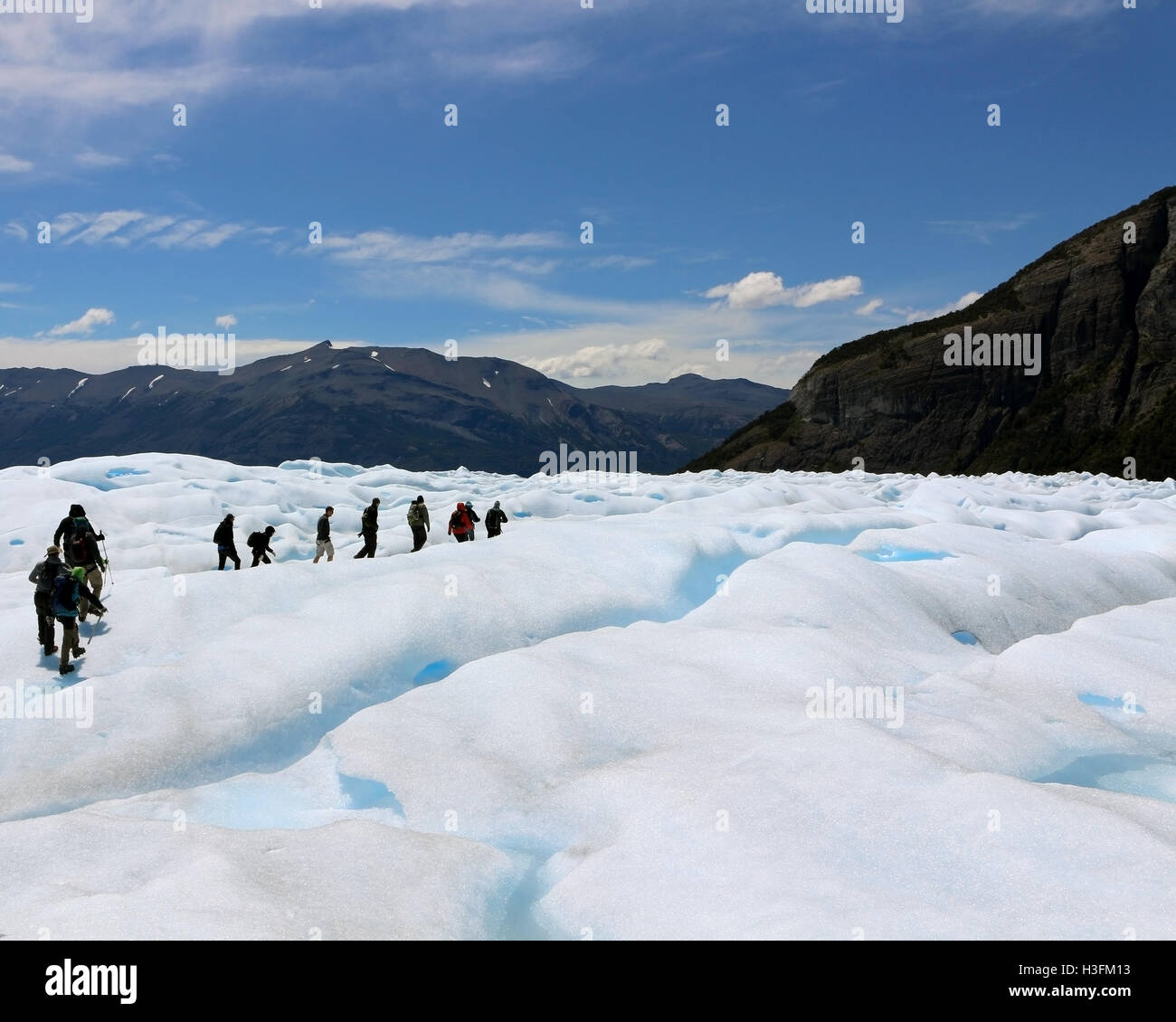People exploring Perito Moreno glaciar in the middle of crevices formed by the ice drift Stock Photo