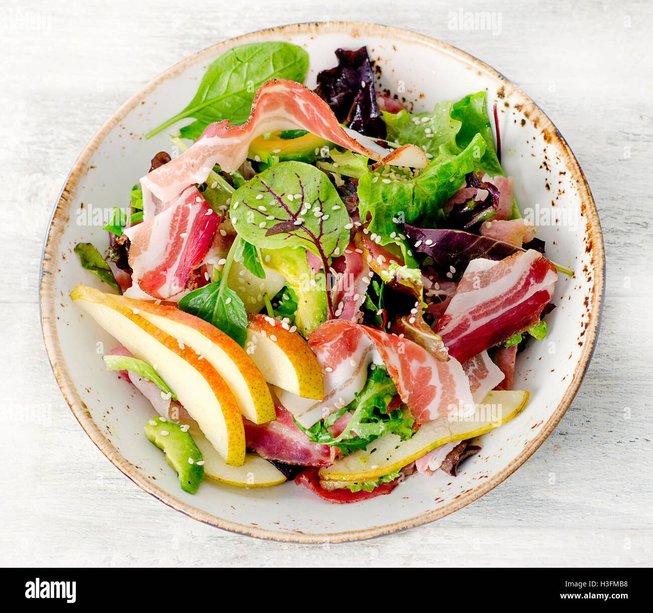 Fresh mixed salad with pancetta and pear. Top view Stock Photo
