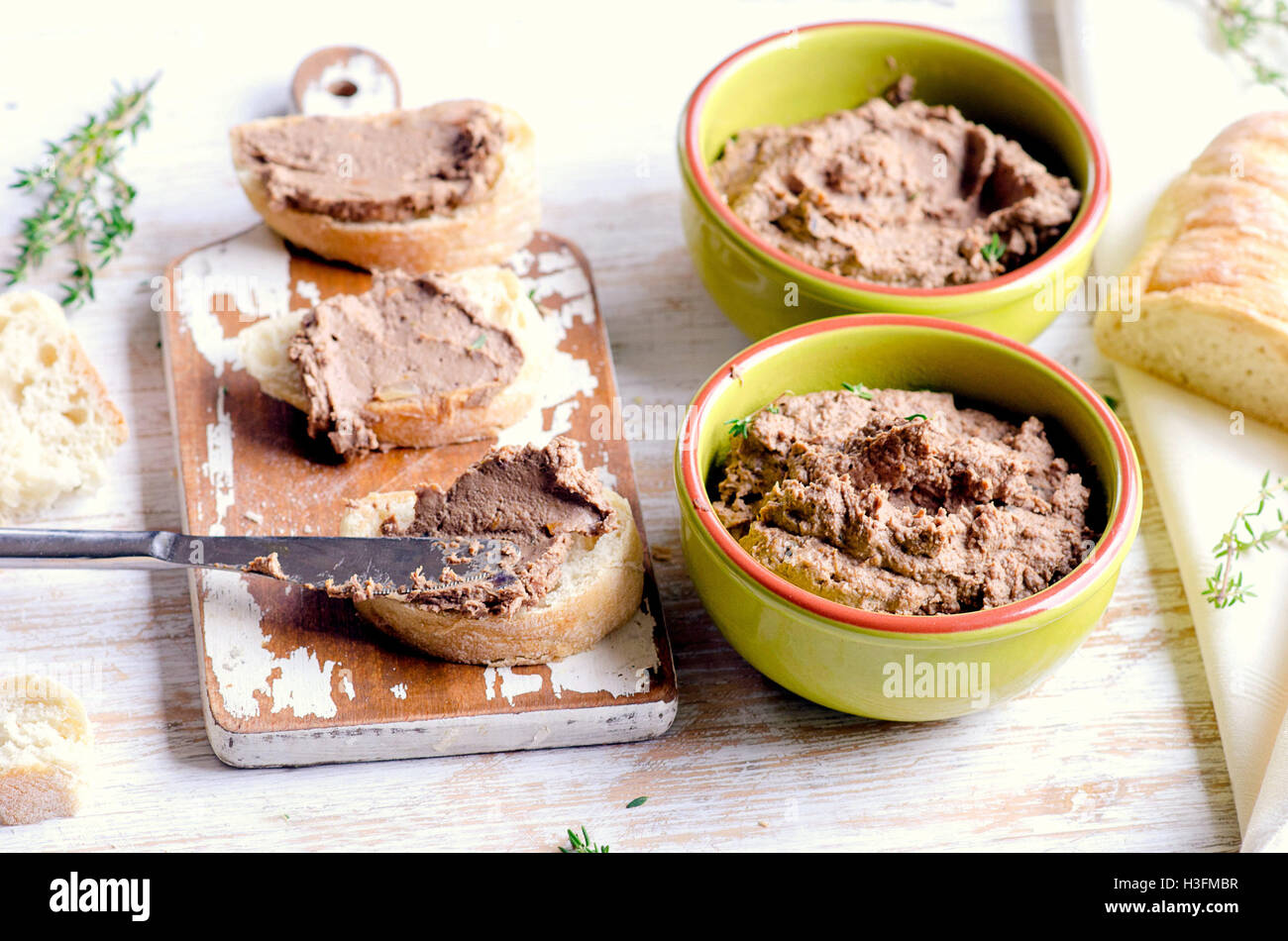 Chicken liver pate with bread on a white wooden board. Selective focus Stock Photo