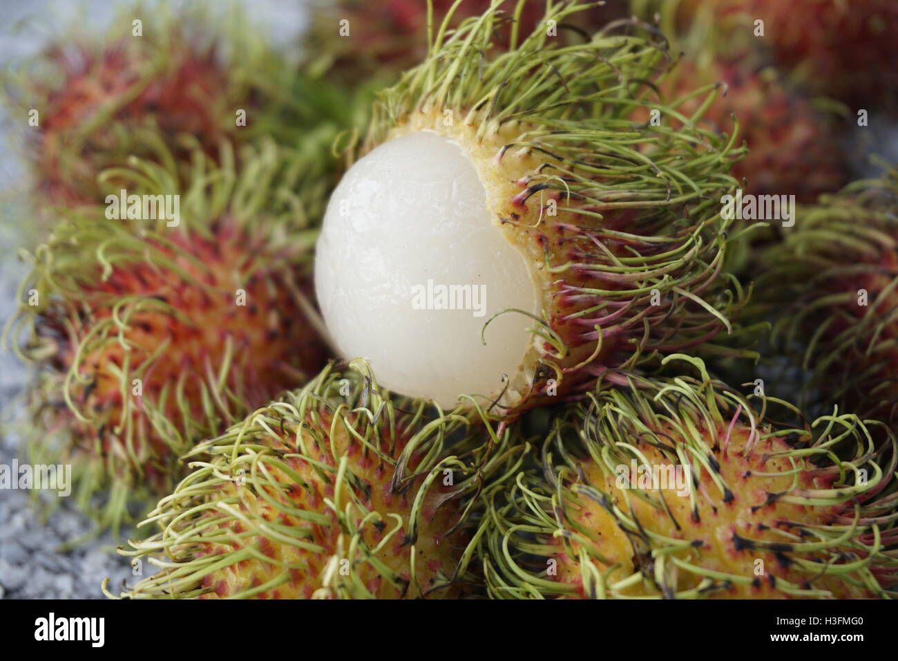 Nephelium lappaceum, rambutan fruit with exposed white flesh Stock Photo