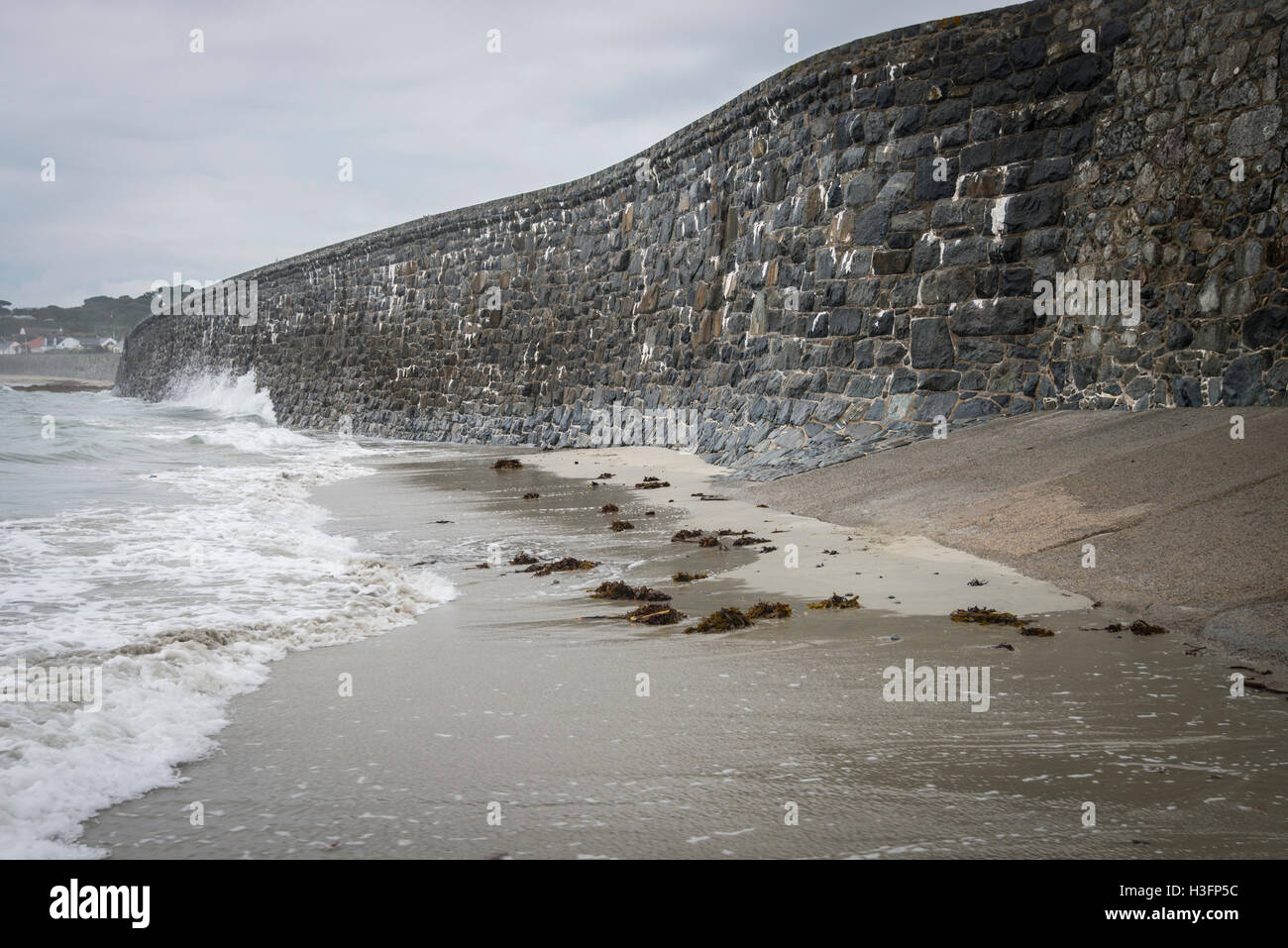 High granite sea wall with waves at base. Stock Photo