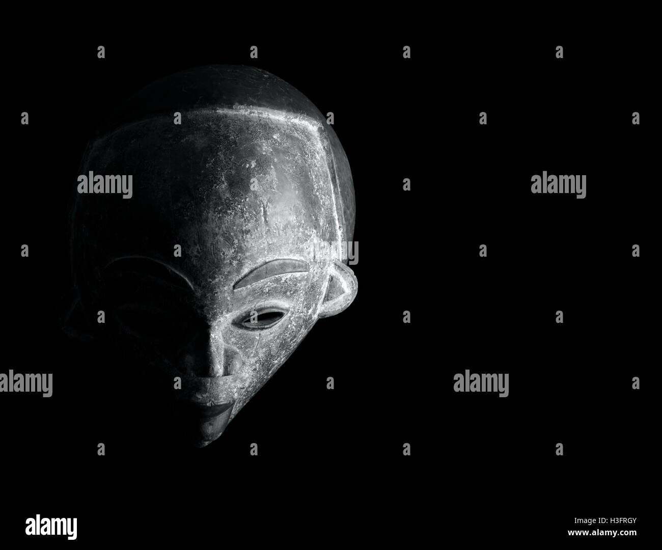 African culture, carved mask on a black background Stock Photo