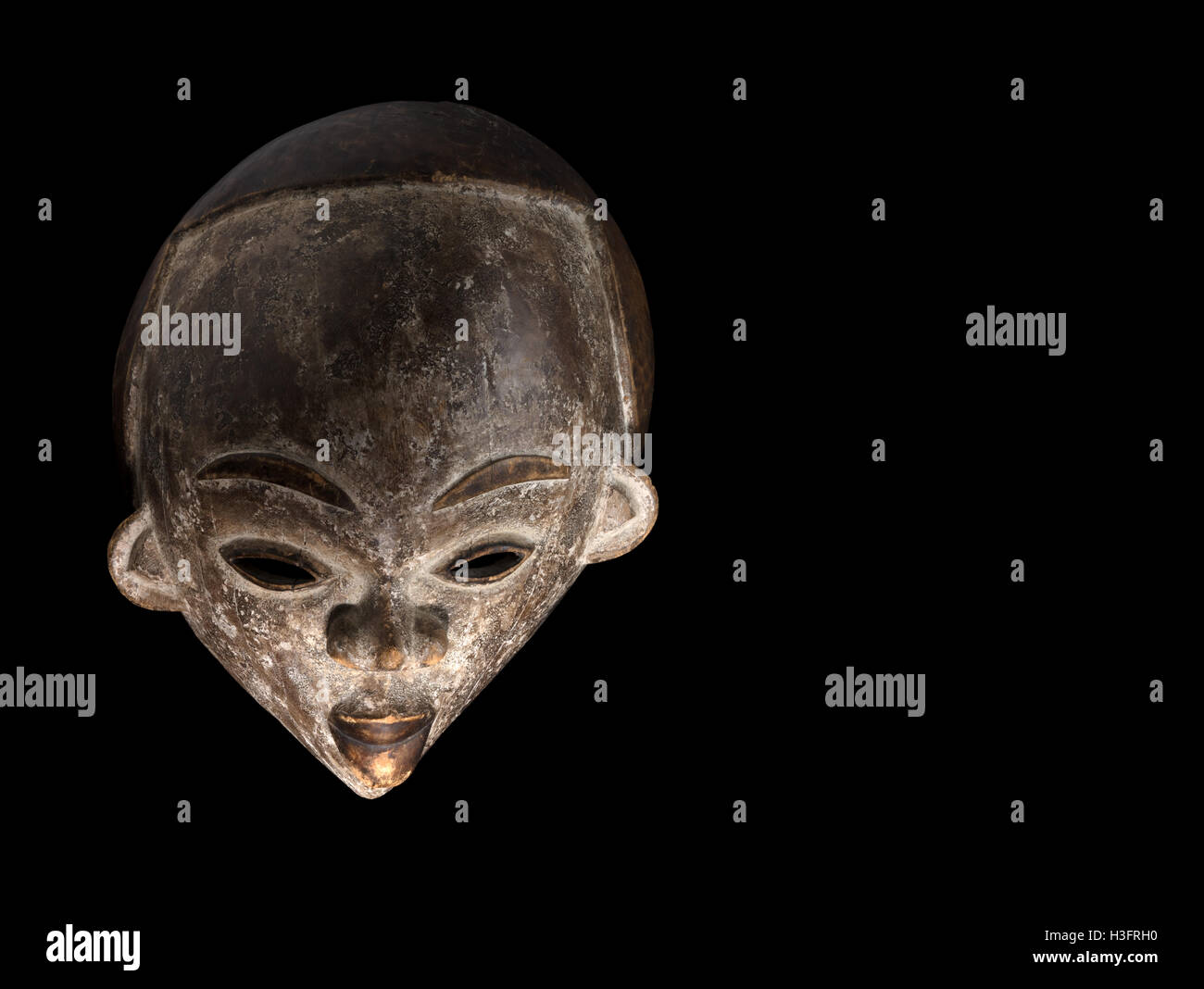 African culture, carved mask on a black background Stock Photo
